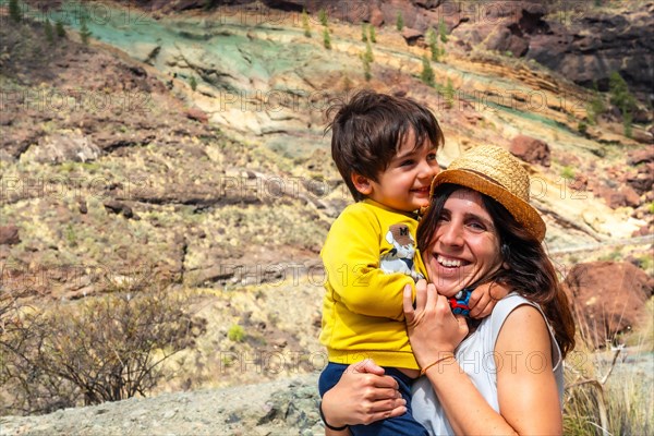 Family of mother and son enjoying at the Natural Monument Azulejos de Veneguera or Rainbow Rocks in