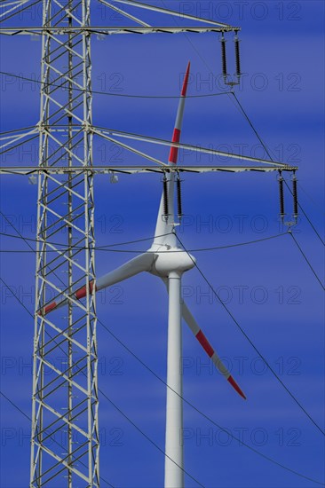 Power pylon with high-voltage lines and wind turbines at the Avacon substation Helmstedt,
