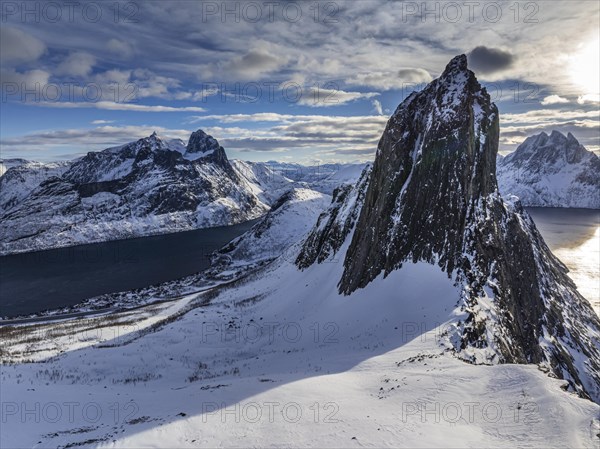 Aerial view of Bergen by the sea, fjord, sunbeams, winter, snow, Mount Segla, Senja, Troms,