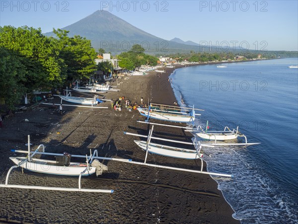 Fishermen loading fish from their outrigger boats in the morning on the black beach of Amed, Amed,