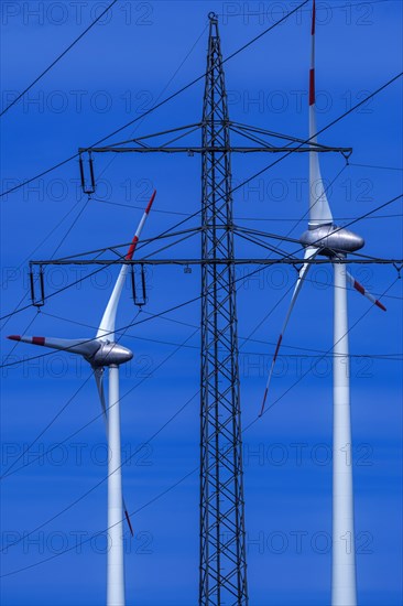 Power pylon with high-voltage lines and wind turbines at the Avacon substation Helmstedt,