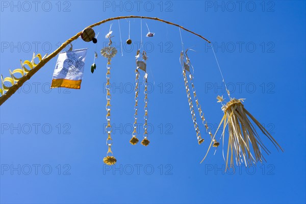 Artfully woven palm leaf jewellery on bamboo poles, on a village street in Amed, Karangasem,