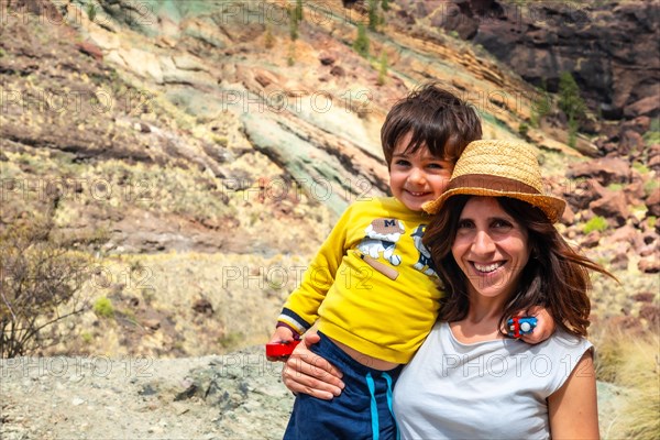Portrait of mother and son enjoying at the Natural Monument Azulejos de Veneguera or Rainbow Rocks