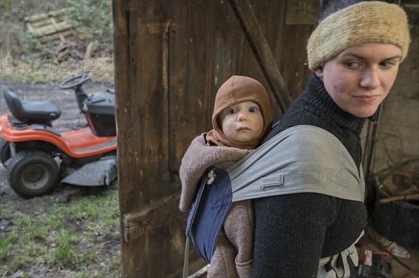 Young mother with her son, 8 months, in a sling on her back, Mecklenburg-Vorpommern, Germany,