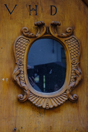 Historic wooden front door with window and inscription VHD in a heritage-protected building in the