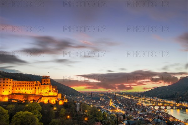 View over an old town with castle or palace rune in the evening at sunset. This town lies in a
