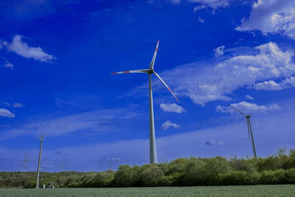 Power pylons with high-voltage lines, mobile phone mast and wind turbines at the Avacon substation