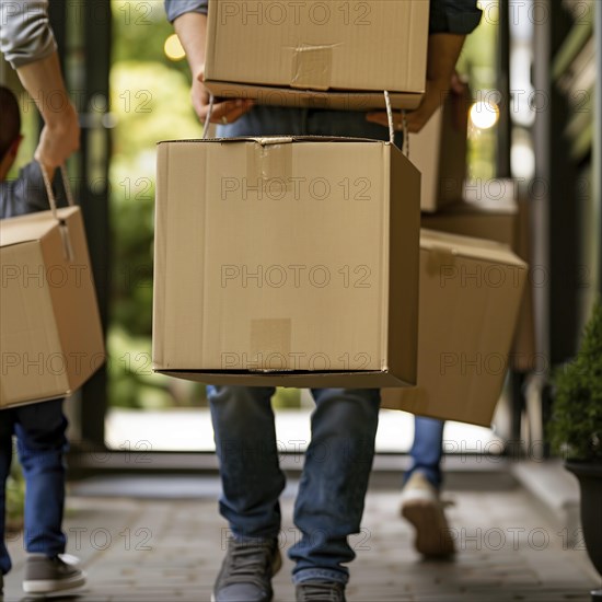 A couple and friends carrying boxes laughing during a move, apartment relocation, apartment