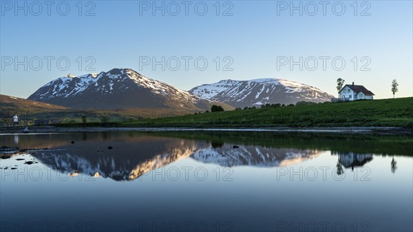 Landscape in Norway. The Balsfjord with a view of mountains and a house by the sea. At night at the