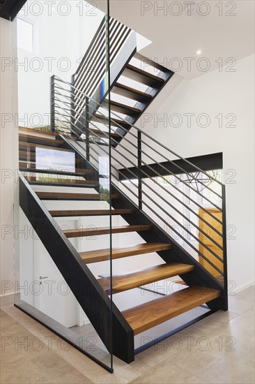 American walnut wood and black powder coated cold rolled steel stairs inside modern cube style