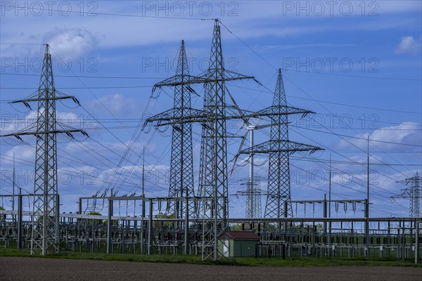 Power pylons with high-voltage lines and wind turbine at the Avacon substation in Helmstedt,