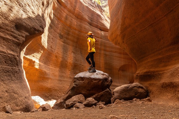 A woman in a yellow t-shirt in the limestone canyon Barranco de las Vacas in Gran Canaria, Canary