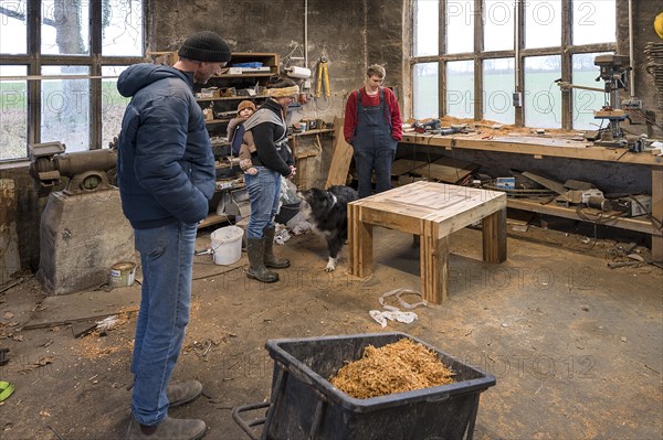 Family inspecting the table built by their son in the workshop, Mecklenburg-Vorpommern, Germany,