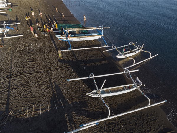 Fishermen unload their catch from their outrigger boat in the morning. Amed, Karangasem, Bali,