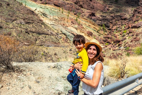 Family of mother and son enjoying at the Natural Monument Azulejos de Veneguera or Rainbow Rocks in