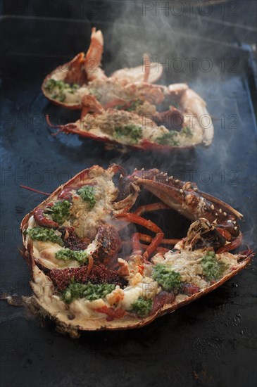 Cooked lobster (homarus) with caviar, vegetables and garlic butter on a plancha, Atlantic coast,