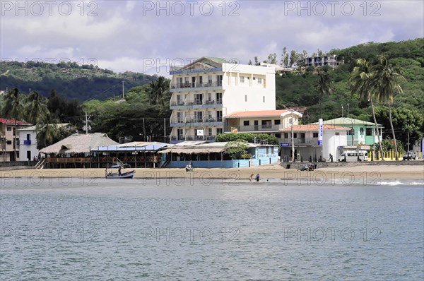 San Juan del Sur, Nicaragua, A view of the shore with a multi-storey building next to palm trees