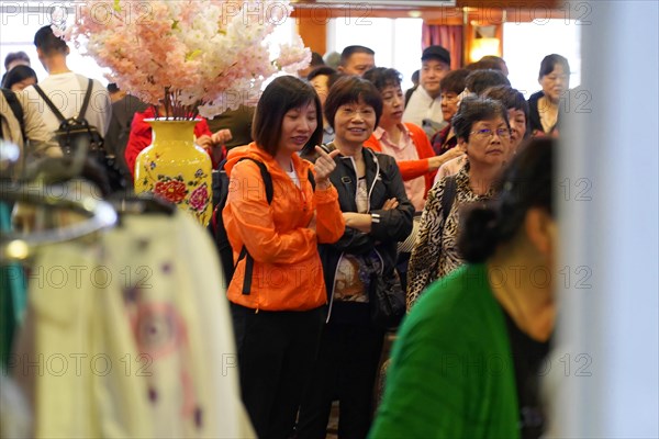 Chongqing, Chongqing Province, China, Cheerful crowd gathers on board a ship, some smiling at the
