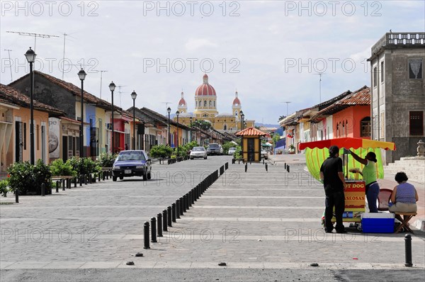 Granada, Nicaragua, View of a busy street running towards a yellow domed cathedral, Central