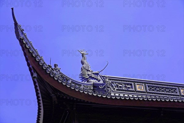 Jade Buddha Temple, Shanghai, detailed view of a temple roof with a dragon sculpture against a blue