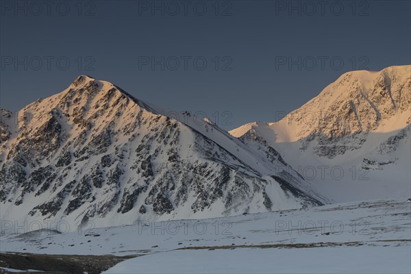 Sunrise over the mountain peaks in the snowy Tavan Bogd National Park, Mongolian Altai Mountains,