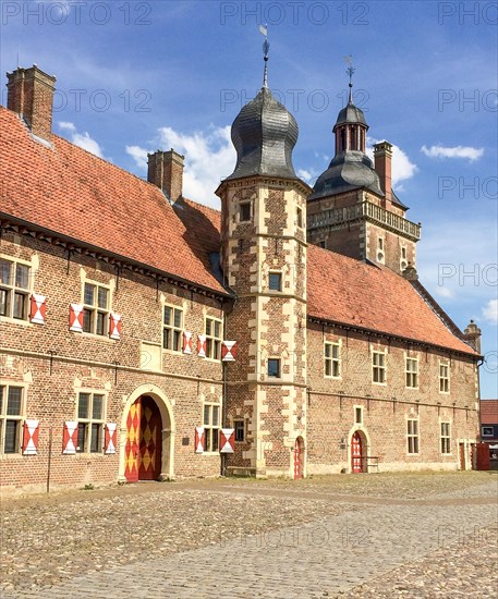 View from the castle courtyard with cobblestones to the outer bailey of the moated castle Schloss