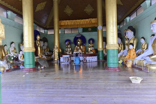 Shwedagon Pagoda, Yangon, Myanmar, Asia, Interior of a temple with Buddha statues and worshippers,