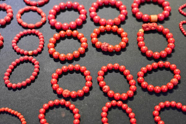 Chongqing, Chongqing Province, China, Asia, Collection of red handmade bracelets on a dark