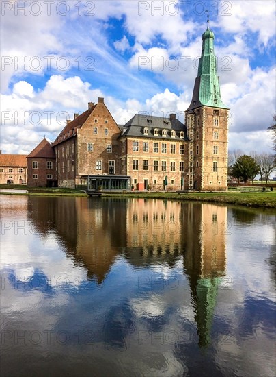View over wide moat to historic moated castle from Renaissance Raesfeld Castle reflected in moat in