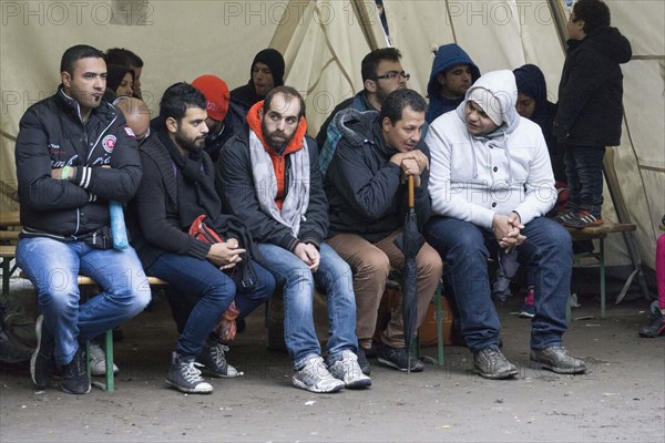 Syrian refugees wait for their registration in cold and wet weather at the Berlin State Office for