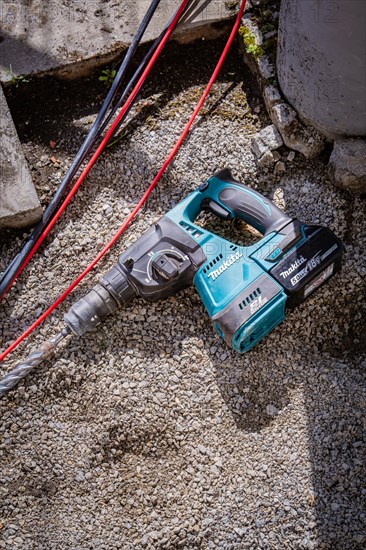 A cordless hammer drill from Makita is lying on the floor, solar systems construction, trade,