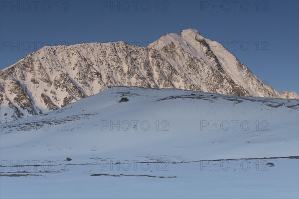 Sunrise over the mountain peaks in the snowy Tavan Bogd National Park, Mongolian Altai Mountains,