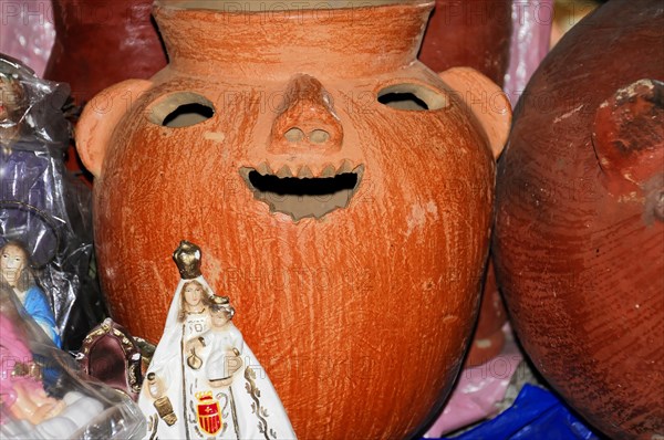 AUGUSTO C. SANDINO Airport, Managua, A red clay vessel with a carved face surrounded by other