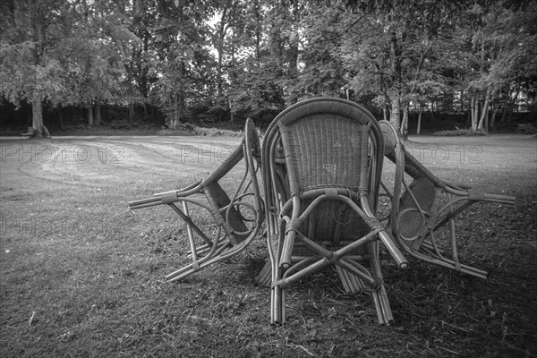 Four chairs are grouped around a table under a tree in a park, St George's Monastery, Isny im