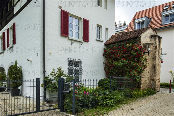 A section of the medieval town wall protrudes from a residential building, Old Town of Isny im