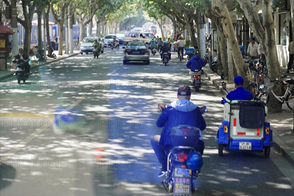 Traffic in Shanghai, Shanghai Shi, View of a busy street with shady trees and various vehicles,