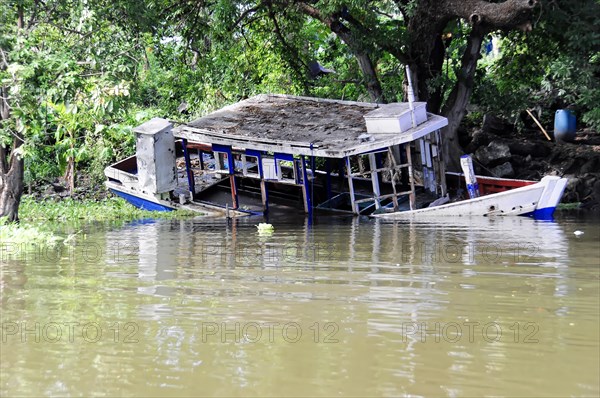 Granada, Nicaragua, Half-sunken boat at Lake Nicaragua surrounded by lush greenery, Central
