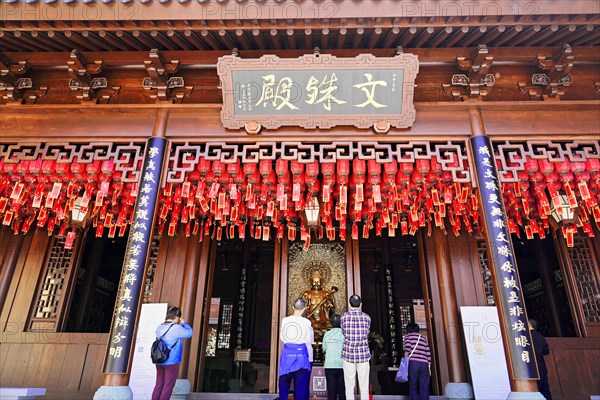 Jade Buddha Temple, Shanghai, Visitors pray in front of a traditional temple with red lanterns and