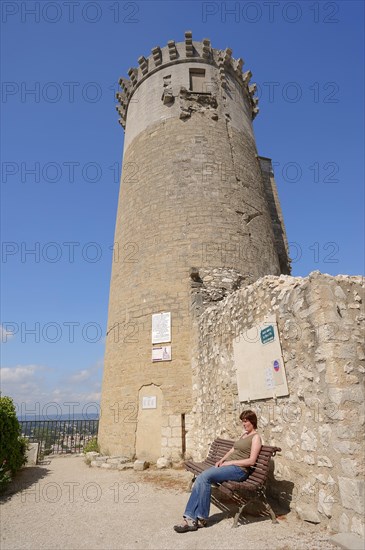 Woman on a bench in front of the castle, Chateaurenard, Bouches-du-Rhone, Provence-Alpes-Cote