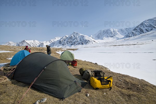 Tents in expedition camp in front of the mountain peaks in the snowy Tavan Bogd National Park,