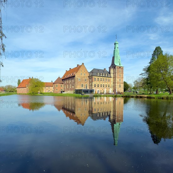 View over moat to historic moated castle from Renaissance Raesfeld Castle reflected in moat in