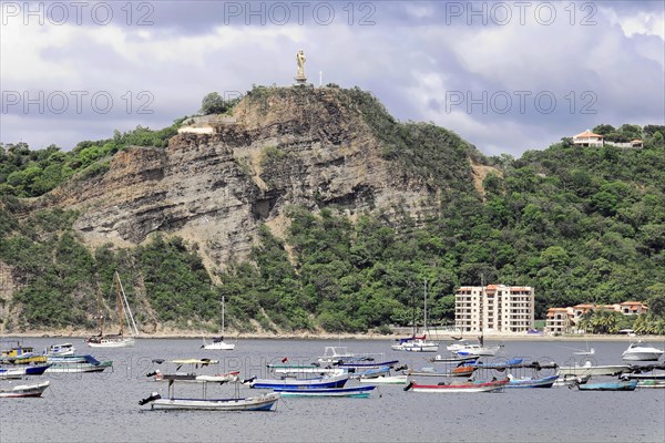 San Juan del Sur, Nicaragua, A statue of Jesus is enthroned on a wooded hill above a bay with