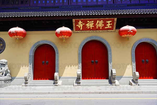 Jade Buddha Temple, Shanghai, Red doors and lanterns on a wall with traditional Chinese