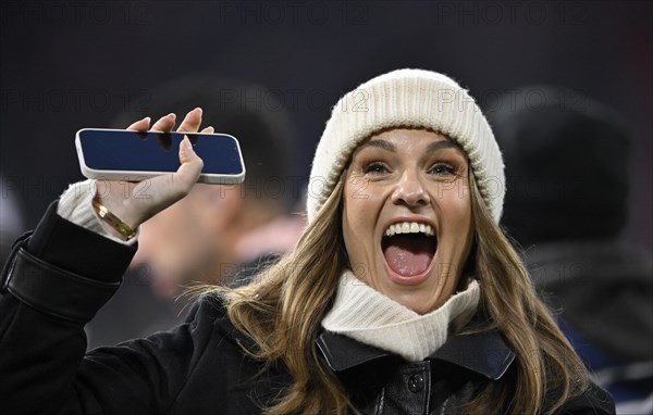 TV presenter Laura Wontorra DAZN, portrait, cap, laughs, waves to her fans, smartphone, mobile
