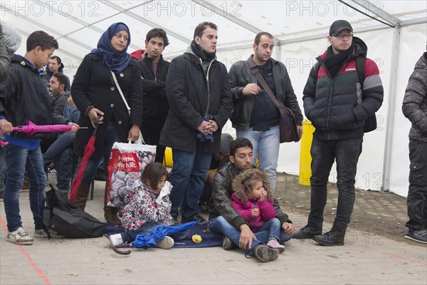 A Syrian refugee family and their children wait in a tent at the Berlin State Office for Health and