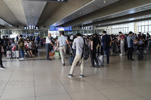 Hongqiao Railway Station, Shanghai, China, Asia, Travellers waiting in a brightly lit airport area,