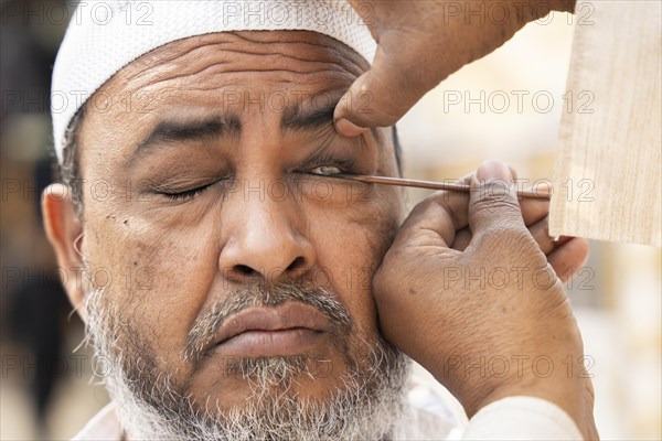 GUWAHATI, INDIA, APRIL 11: A Muslim man applies Surma on eyes during Eid Al-Fitr in Guwahati, India