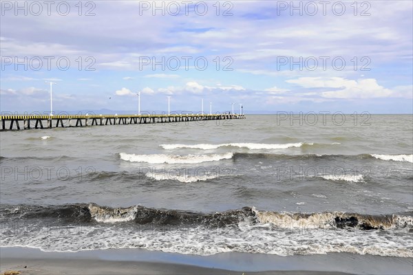 Granada, Nicaragua, Calm waves of Lake Nicaragua meet a long pier under a cloudy sky, Central