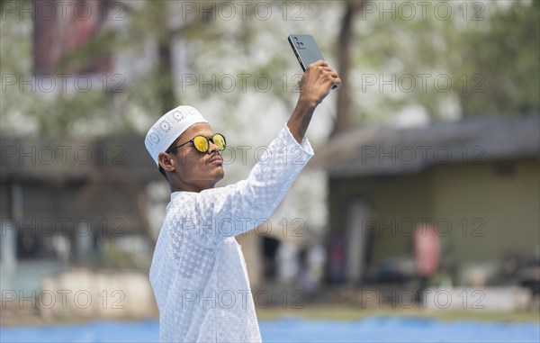 GUWAHATI, INDIA, APRIL 11: A Muslim person takes selfie after perform Eid al-Fitr prayer at Eidgah