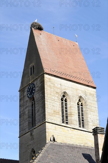 Eguisheim, Alsace, France, Europe, A church tower with a stork's nest on top under a clear blue